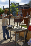 man grilling meat for sale - Portobello, Colón, Panama, Central America - photo by H.Olarte