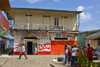 A group of kids chat as an adult passes by, in front of a small town saloon. Portobello, Colón, Panama, Central America - photo by H.Olarte